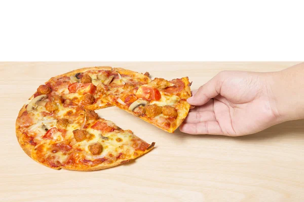 Hand met lekkere smaakvolle pizza op hout — Stockfoto