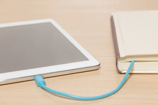 Tablet PC aangesloten op het oude boek met een kabel — Stockfoto