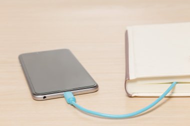 Akıllı telefon eski kitabın bir kablo ile bağlı