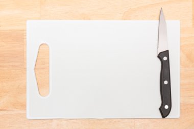 Ahşap masa üzerinde plastik kasap ve bıçak Üstten Görünüm