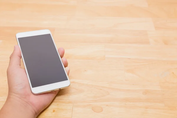 Hand met slimme mobiele telefoon op houten tafel achtergrond met Co — Stockfoto