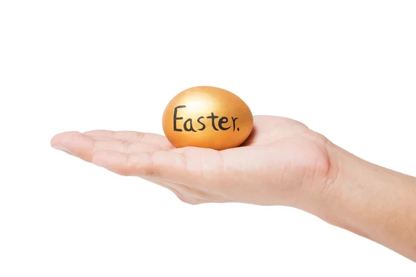 Huevo de Pascua de oro en la mano — Foto de Stock