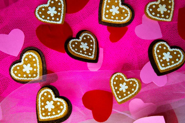 Sevgililer Günü için kalpleri ve çiçekleri olan pembe tekstil arka planında hatıra oyuncak ayılar.