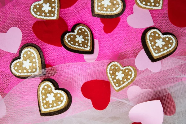 Sevgililer Günü için kalpleri ve çiçekleri olan pembe tekstil arka planında hatıra oyuncak ayılar.
