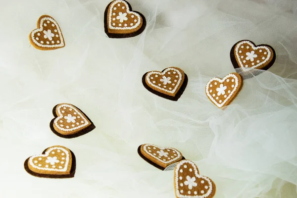 Sevgililer Günü için kalpleri ve çiçekleri olan pembe tekstil arka planında hatıra oyuncak ayılar.