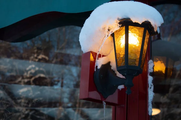 Kar yağışı sonrası yumuşacık karla kaplı eski turuncu bir fener.