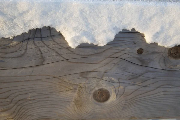 Tahta dokunun yarısı karla kaplı.