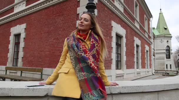 Portrait of young happy woman by the brick wall — Stock Video