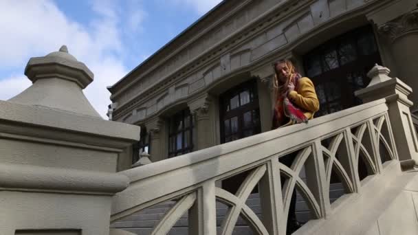 Портрет молодой девушки-подростка, сидящей на парадной лестнице — стоковое видео