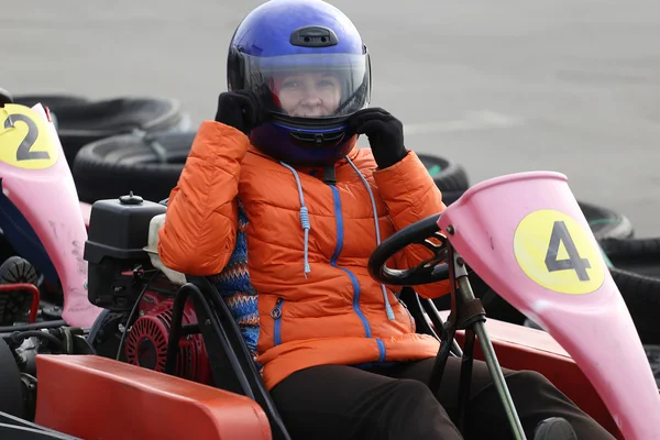 Lány vezetési go-kart autó sebességgel egy játszótér versenyautó pályán. — Stock Fotó