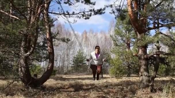 Homel, Vitryssland - 3 April 2016: Familj i en skog glade rida på en gunga. — Stockvideo