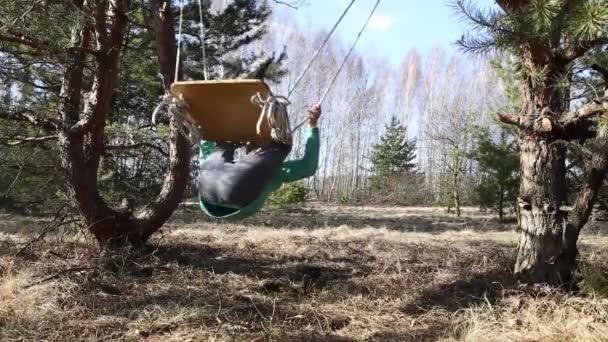 Homel, Wit-Rusland - 3 April 2016: Familie in een bos glade rit op een schommel. — Stockvideo