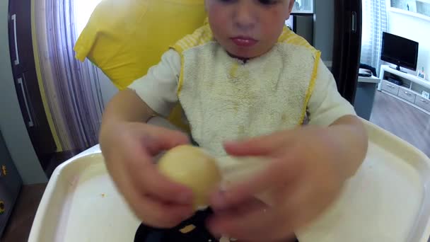 Niño limpia los huevos de la cáscara para el almuerzo — Vídeos de Stock