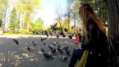 Güzel kız parkta güvercin besleme