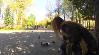 Güzel kız parkta güvercin besleme