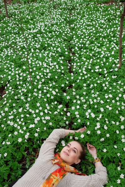 Красива чуттєва дама лежить на квітковому лузі — стокове фото
