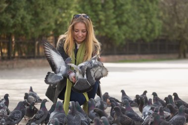 Kız ve güvercinler fotoğrafı. parkta güvercin besleme