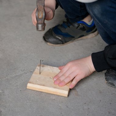 Çocuk bir çivi çekiç ile düzeltmek öğrenme