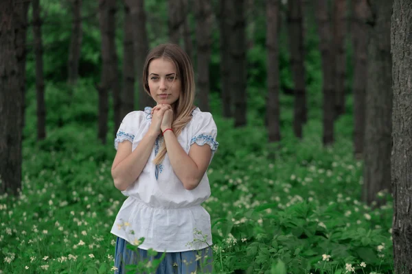 Красива молода дівчина крупним планом в білій сорочці, на фоні зеленого лісу — стокове фото