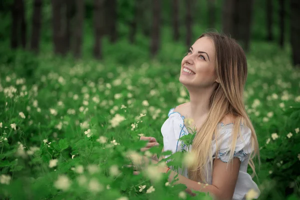 Menina bonita close-up em uma camisa branca, contra um fundo de floresta verde — Fotografia de Stock