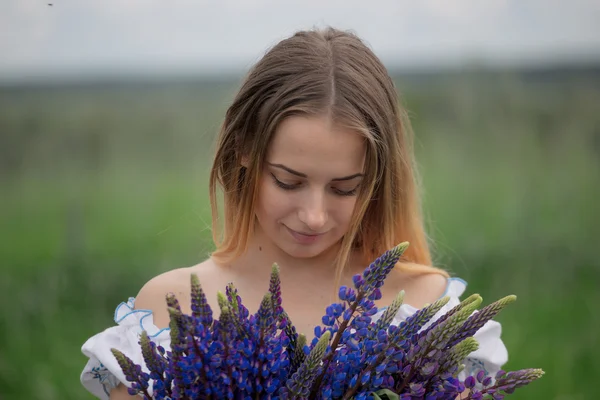 フィールド内の花と美しい若い女性の肖像画 — ストック写真