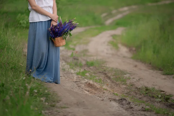 Porträt einer schönen jungen Frau mit Blumen auf dem Feld — Stockfoto