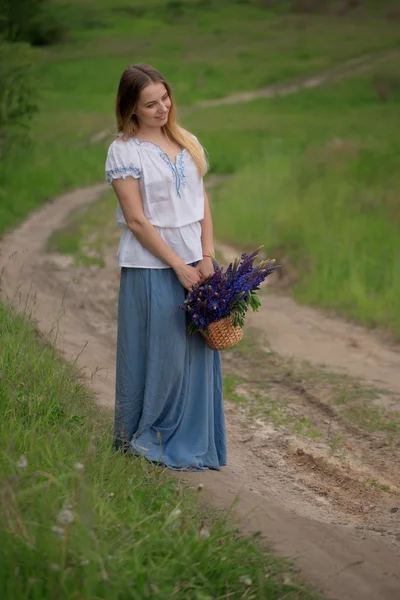 フィールド内の花と美しい若い女性の肖像画 — ストック写真