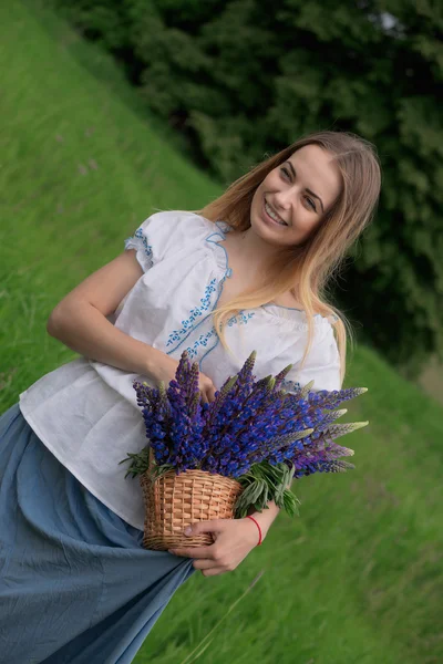 フィールド内の花と美しい若い女性の肖像画 — ストック写真