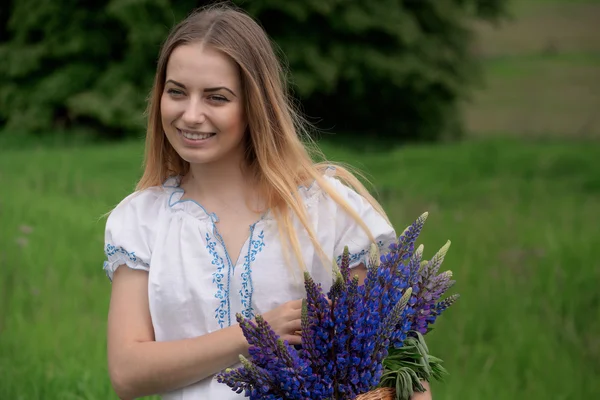 Portrait de belle jeune femme avec des fleurs dans le champ — Photo