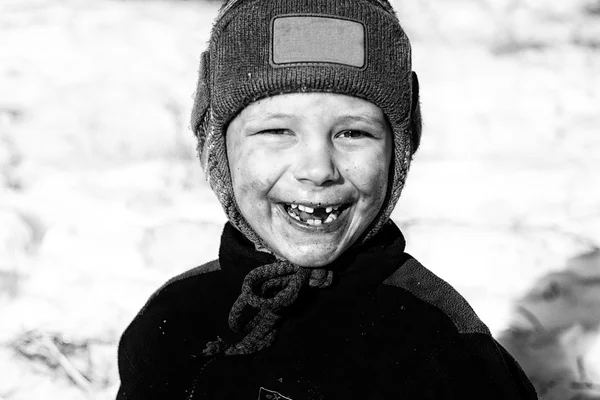 Een lachend kind zonder tanden met een lieveheersbeestje op zijn Wang dicht omhoog, zwart-wit foto — Stockfoto