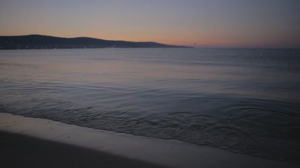 Солнце поднимается над горизонтом и утренние волны морского серфинга на песчаном пляже — стоковое видео