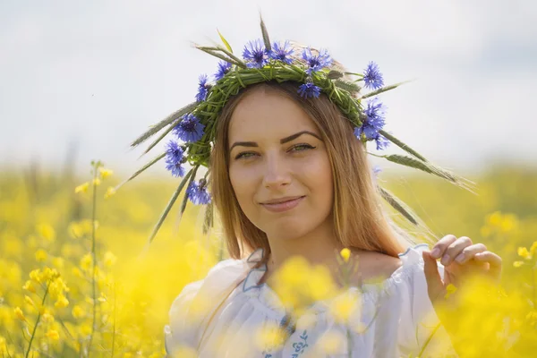 Lány a fején, sárga virágos mező színes virágok koszorút — Stock Fotó