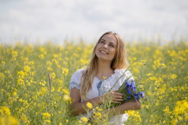 başında, bir çiçekli sarı alanda renkli çiçek çelenk ile kız