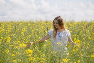 başında, bir çiçekli sarı alanda renkli çiçek çelenk ile kız