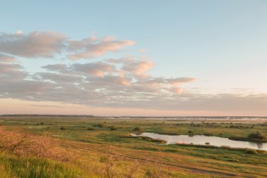 Bir nehir ve bu yolda çim alanının üzerinde puslu gündoğumu