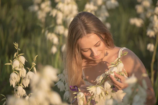 Princesse. Jeune belle jolie femme posant en robe de luxe longue soirée contre les buissons aux fleurs blanches — Photo