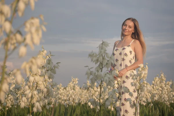 Princesse. Jeune belle jolie femme posant en robe de luxe longue soirée contre les buissons aux fleurs blanches — Photo