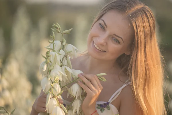 Princesse. Jeune belle jolie femme posant en robe longue contre dans le domaine avec des fleurs blanches — Photo