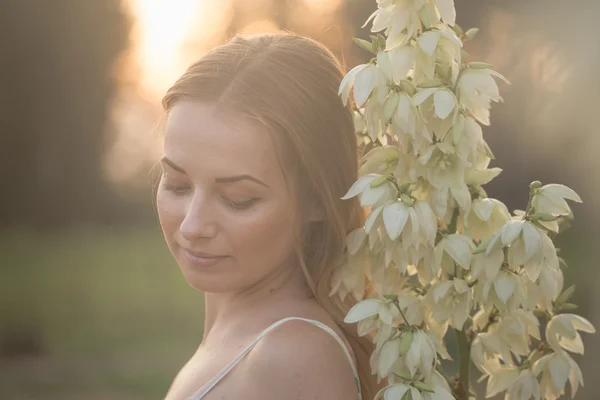Close-up πορτρέτο... Όμορφη όμορφη κοπέλα που θέτουν σε μακρύ φόρεμα ενάντια στο πεδίο με τα άσπρα λουλούδια — Φωτογραφία Αρχείου