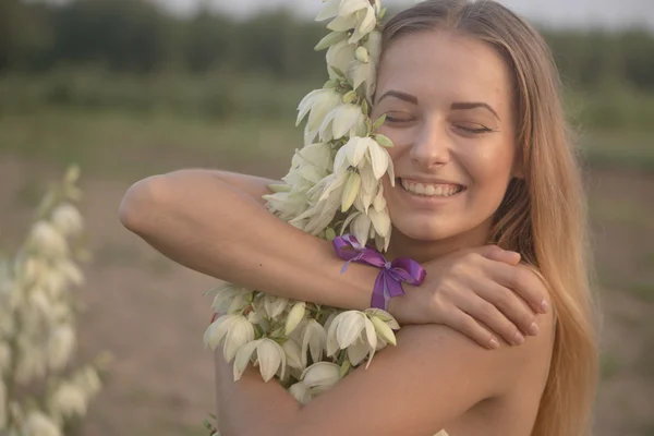 Retrato de cerca.. Joven hermosa mujer bonita posando en vestido largo en contra en el campo con flores blancas — Foto de Stock