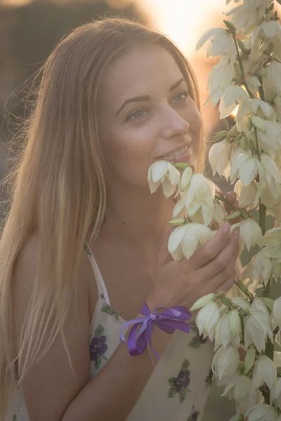 Portrait en gros plan.. Jeune belle jolie femme posant en robe longue contre dans le domaine avec des fleurs blanches — Photo