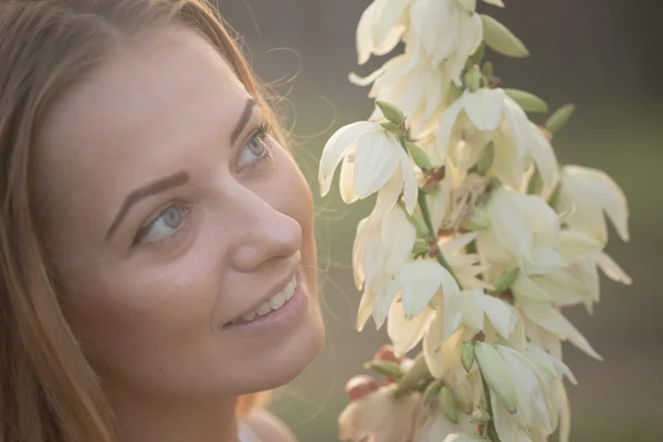 Portrait en gros plan.. Jeune belle jolie femme posant en robe longue contre dans le domaine avec des fleurs blanches — Photo