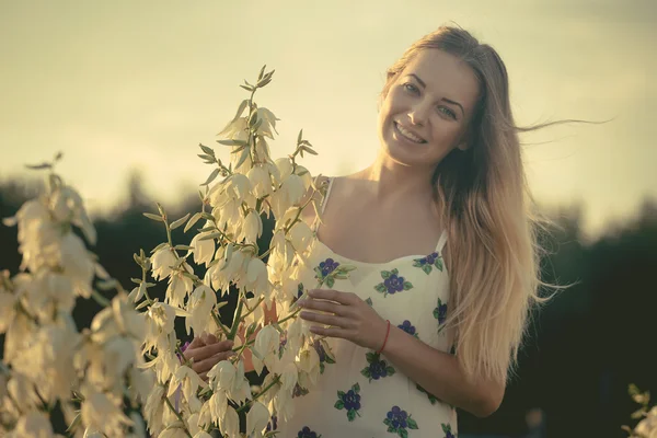 Princesse. Jeune belle jolie femme posant en robe de luxe longue soirée contre les buissons aux fleurs blanches — Photo