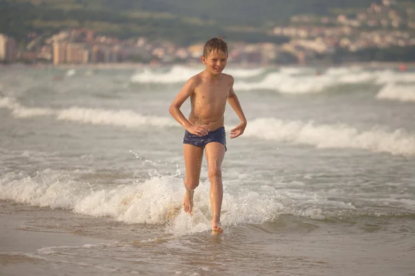 Boy frolics in the sea with splashes and waves — Stock Photo, Image