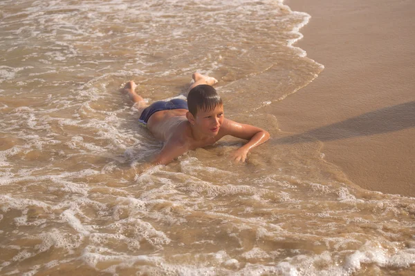 Boy frolics in the sea with splashes and waves — Stock Photo, Image