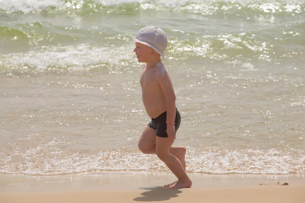 Ευτυχισμένο μωρό τρέχει από surf στην παραλία — Φωτογραφία Αρχείου