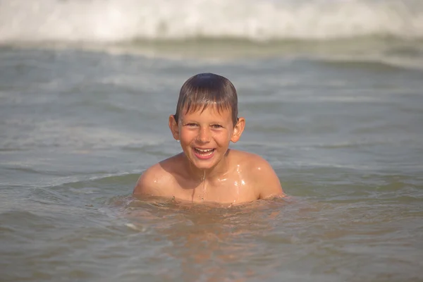 Ευθυμίες αγόρι στη θάλασσα με πιτσιλιές και κύματα — Φωτογραφία Αρχείου