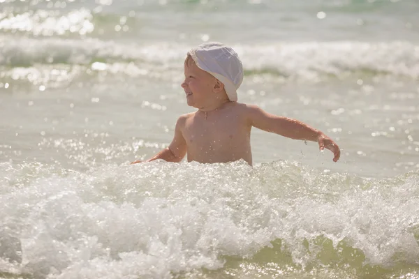 Frolics menino no mar com salpicos e ondas — Fotografia de Stock