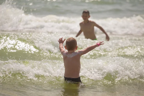 Frolics menino no mar com salpicos e ondas — Fotografia de Stock