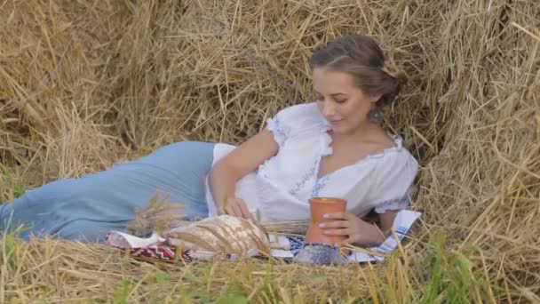 Jeune belle fille est boire du lait d'une cruche sur la nature — Video